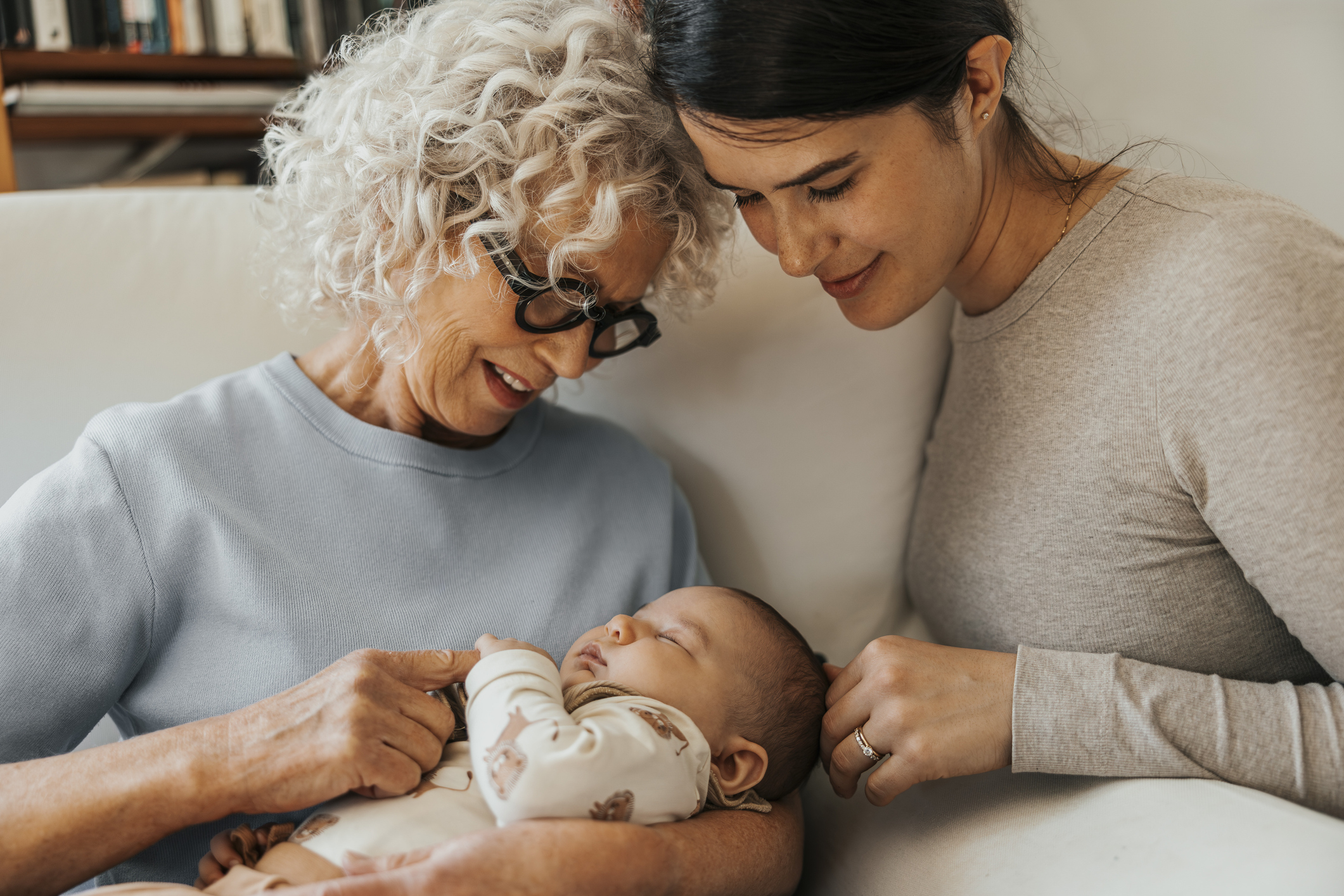 Grandmother holding a baby with young mother looking on