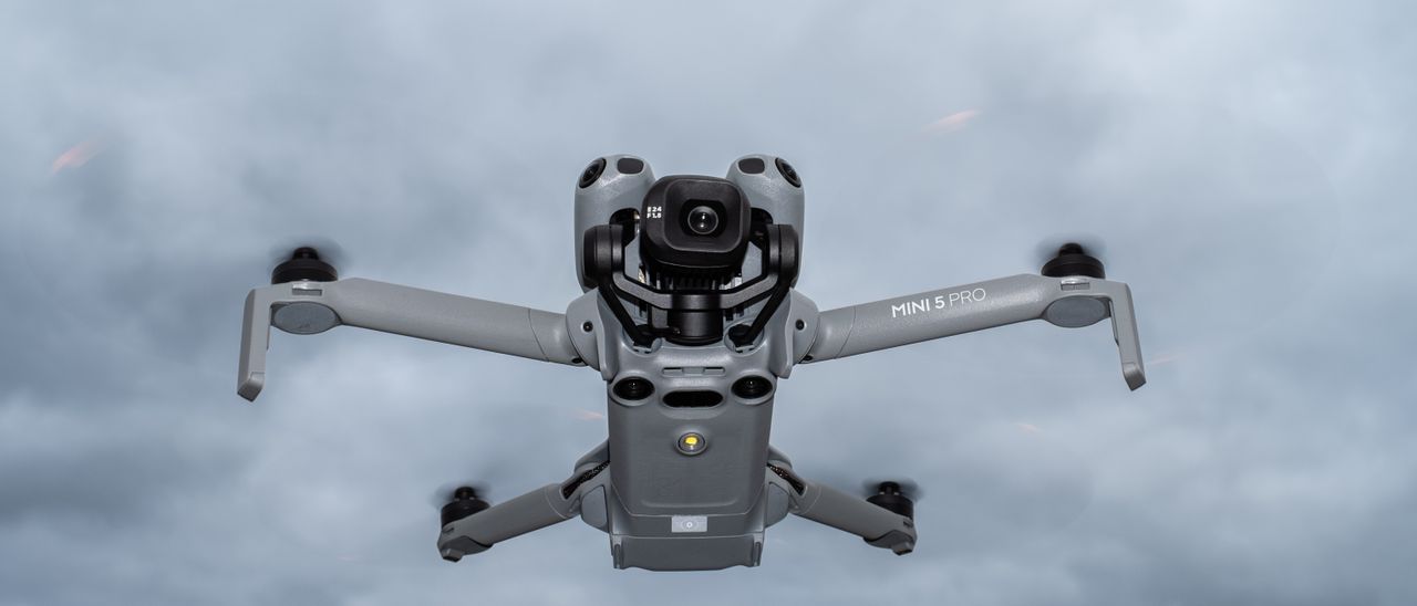 DJI Mini 5 Pro in flight against a cloudy sky