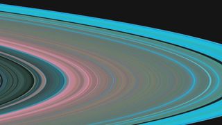 A false-color radio-science image of particle size distribution in Saturn's rings. Pink and red areas hold more large particles; cyan and blue regions contain mostly smaller grains.