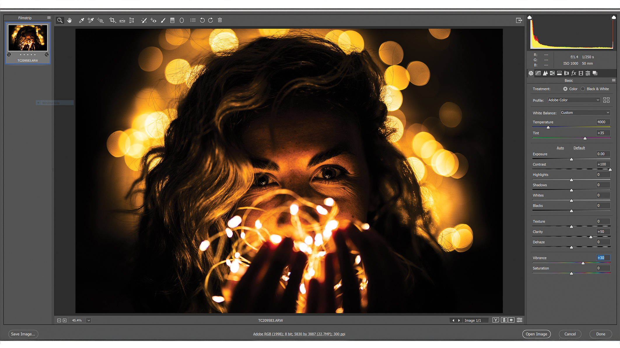 A Photoshop window with editing menus, an image in the center showing a person with wavy hair surrounded by soft, golden bokeh lights that create a warm and dreamy atmosphere