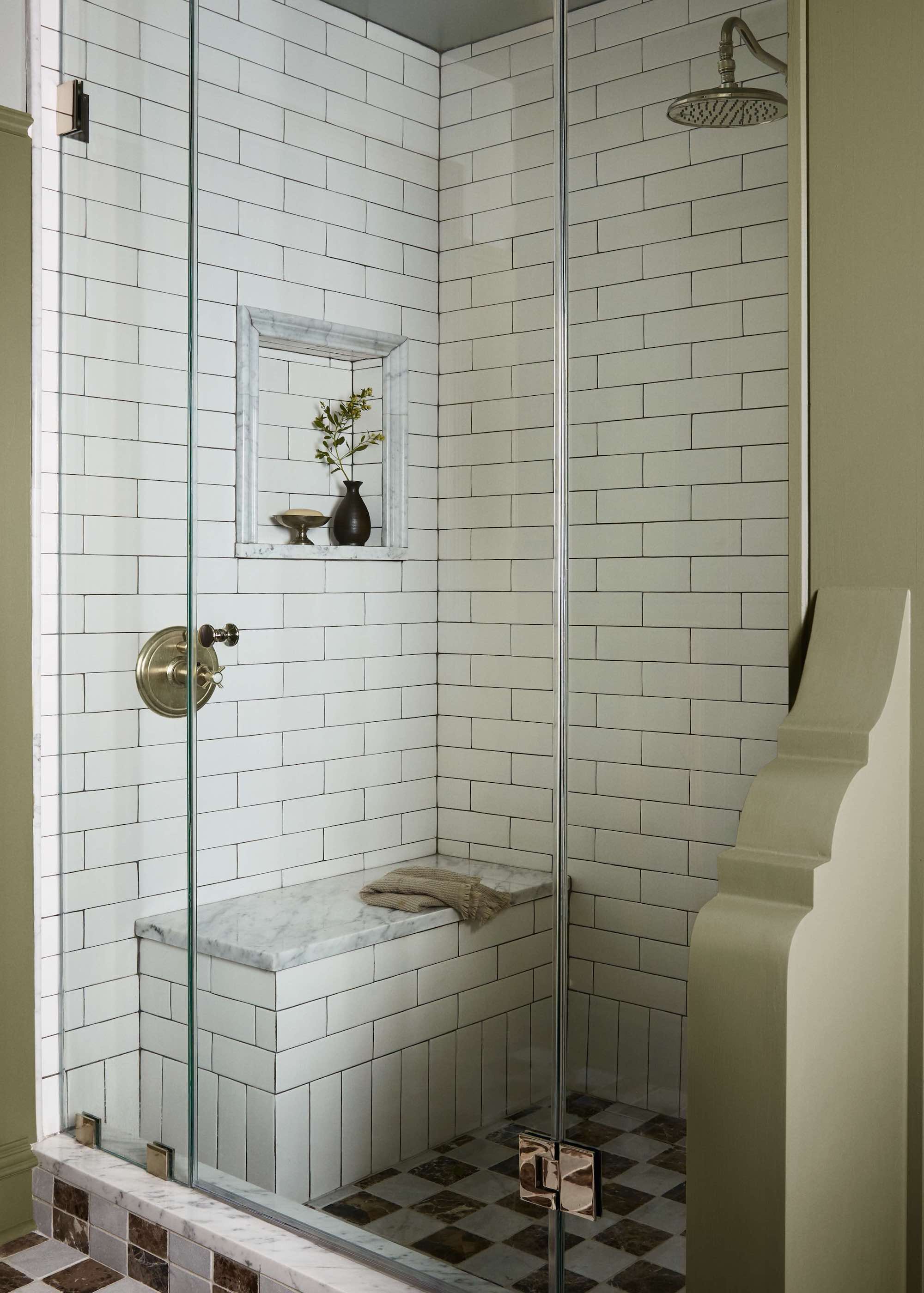 shower with seat and subway tiles in a small bathroom