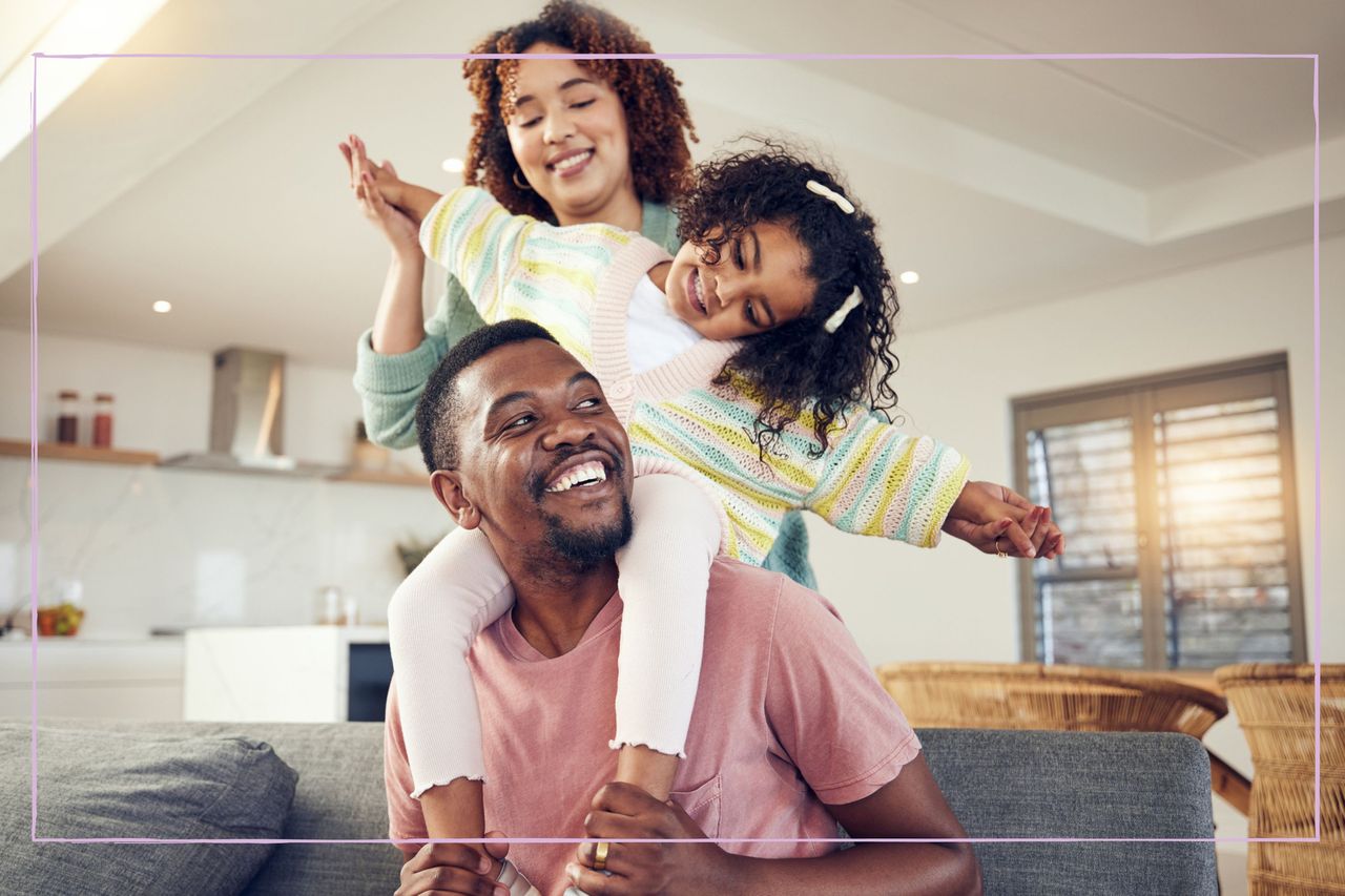 Smiling family of three in their living room