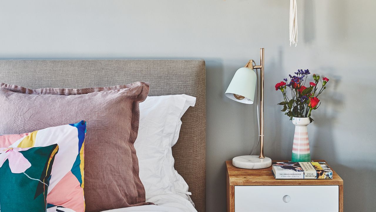 Grey bedroom with pink cushions