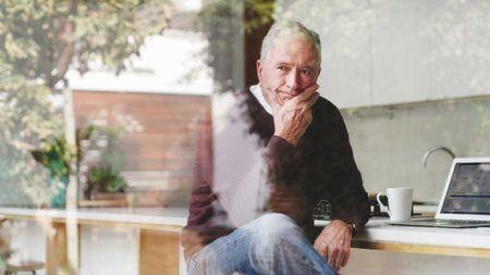 Senior businessman at kitchen table thinking