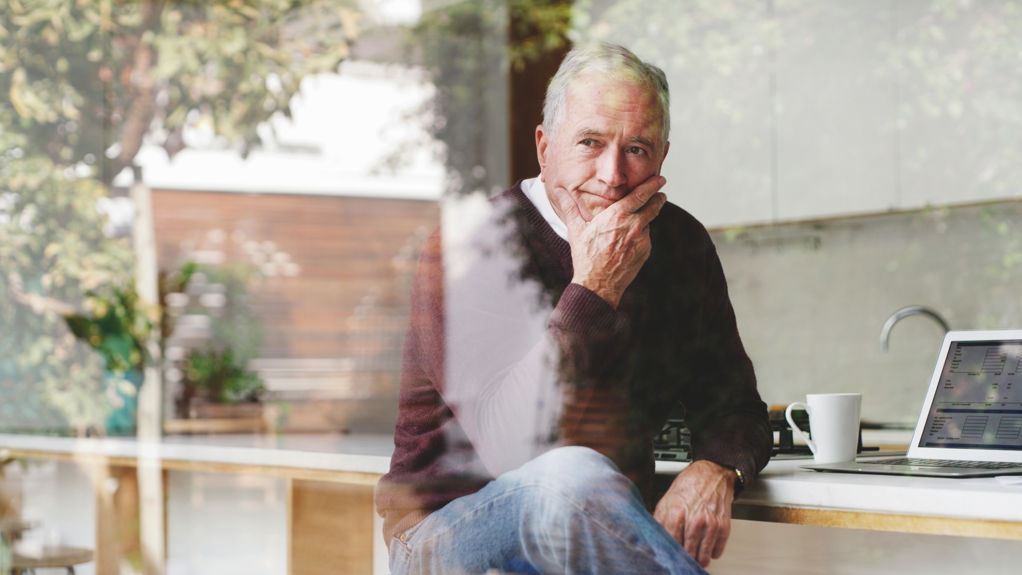 Senior businessman at kitchen table thinking