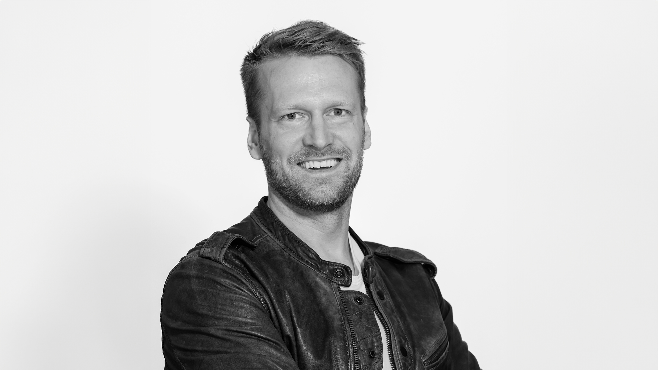 Jonas Lindell wearing a black leather jacket poses against a plain white background
