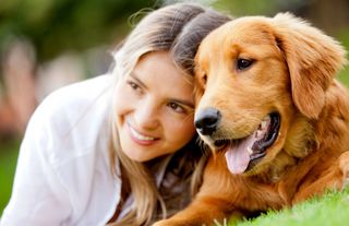 Portrait of a woman with her beautiful dog lying outdoors