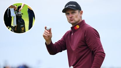 Justin Rose waves to the crowd in a red hoodie