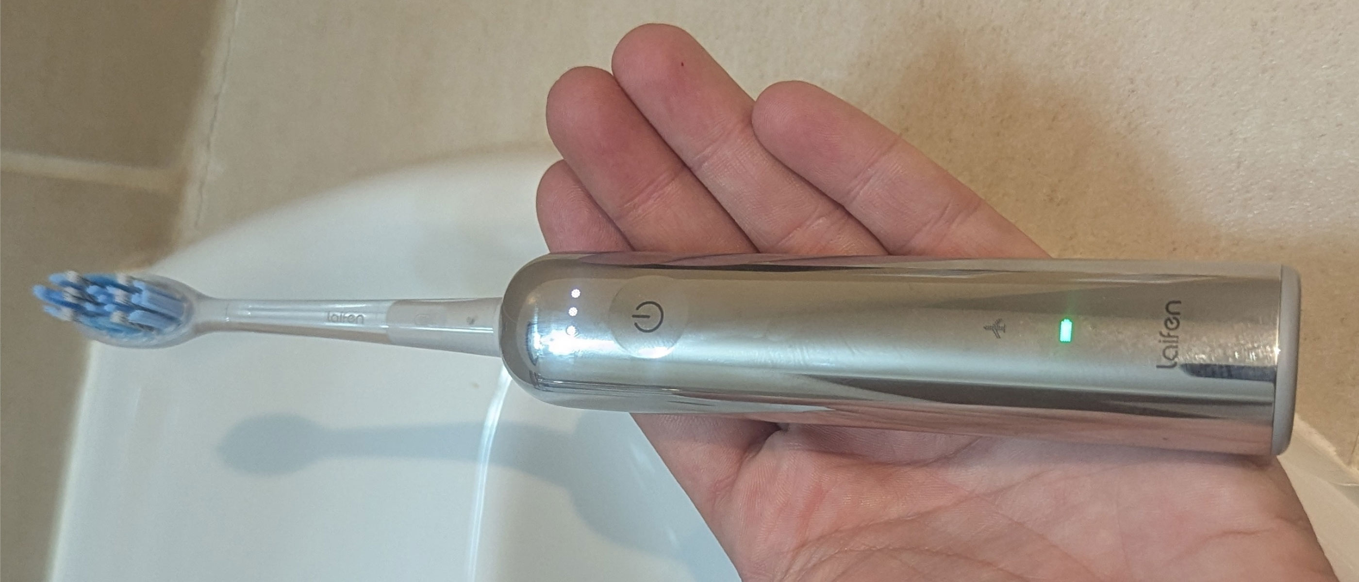 a close-up picture of our reviewer holding the Laifen Wave Pro electric toothbrush