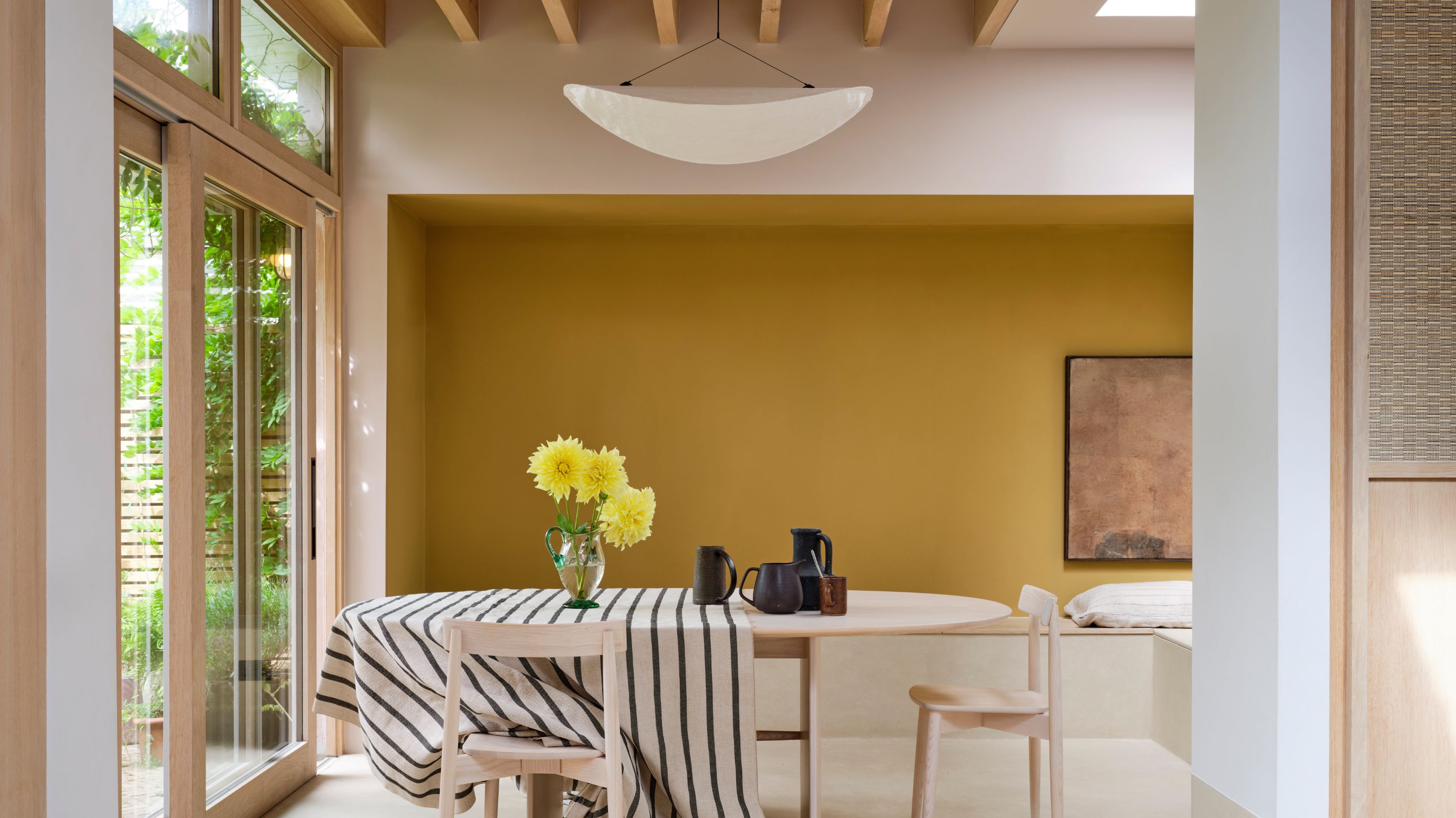 light and airy modern dining room with yellow accent wall