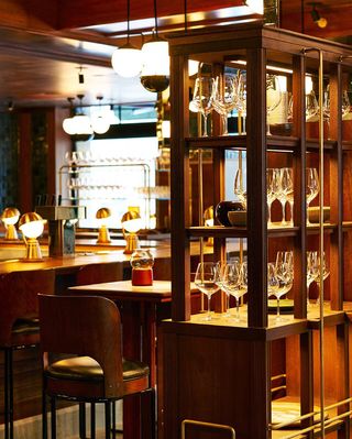 Bar with wine glasses in wooden shelves