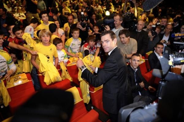 2011 Tour de France winner Cadel Evans signs yellow shirts for fans