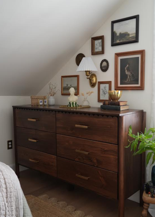 Dark wooden dresser with scallop edge at the top and gold handles.