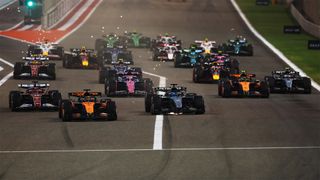 The entire F1 field driving past the exit to the pit lane at the 2025 Bahrain Grand Prix