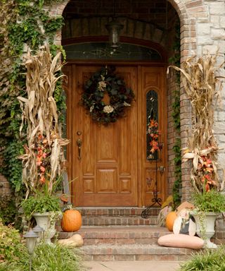autumn front door with dried corn and wreath