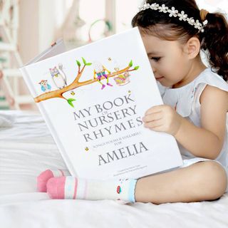 best personalised gifts girl reading nursery rhyme book with her name on it