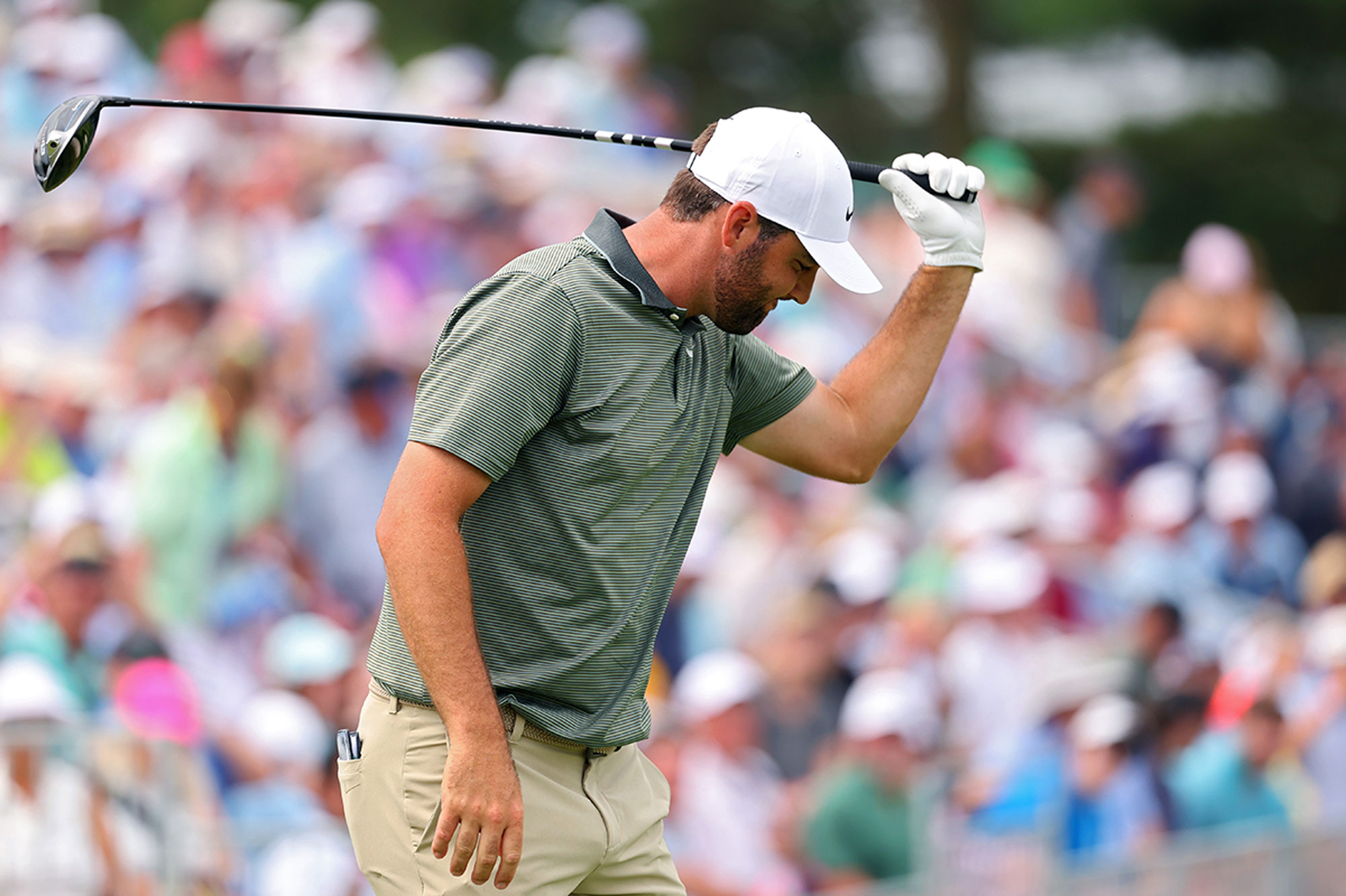 Scottie Scheffler frustratedly whiffing his club down towards the ground at Oakmont Country Club during the US Open