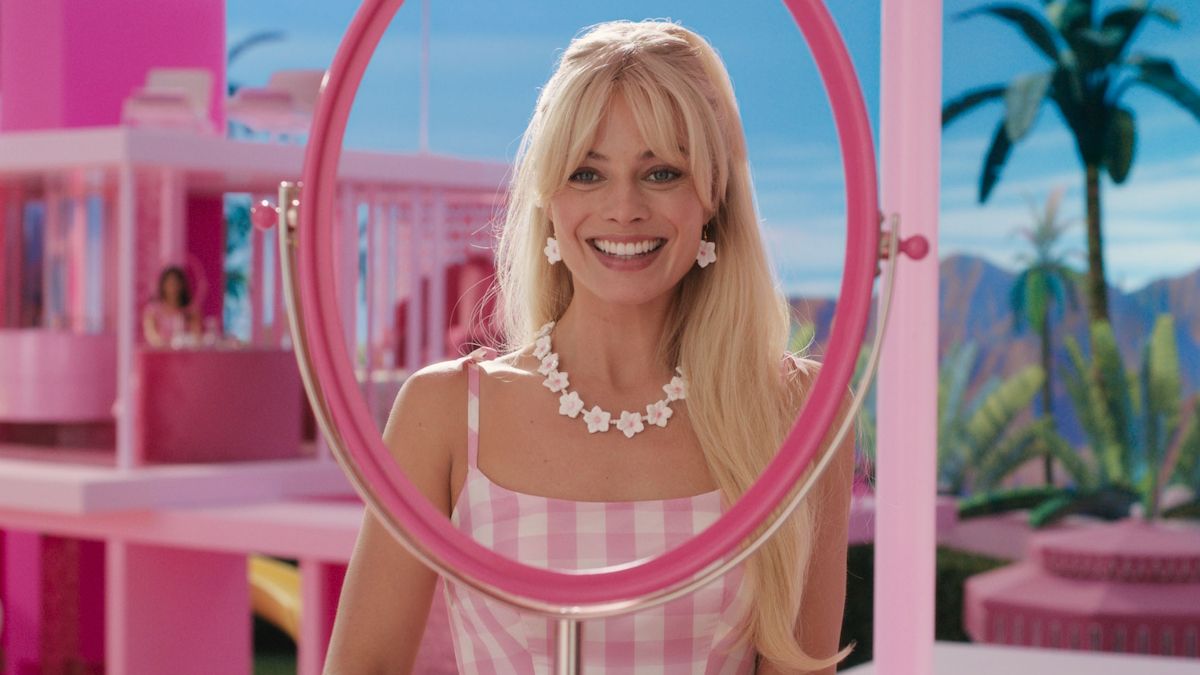 Margot Robbie sits in front of a see-through mirror in Barbie