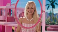 Margot Robbie sits in front of a see-through mirror in Barbie