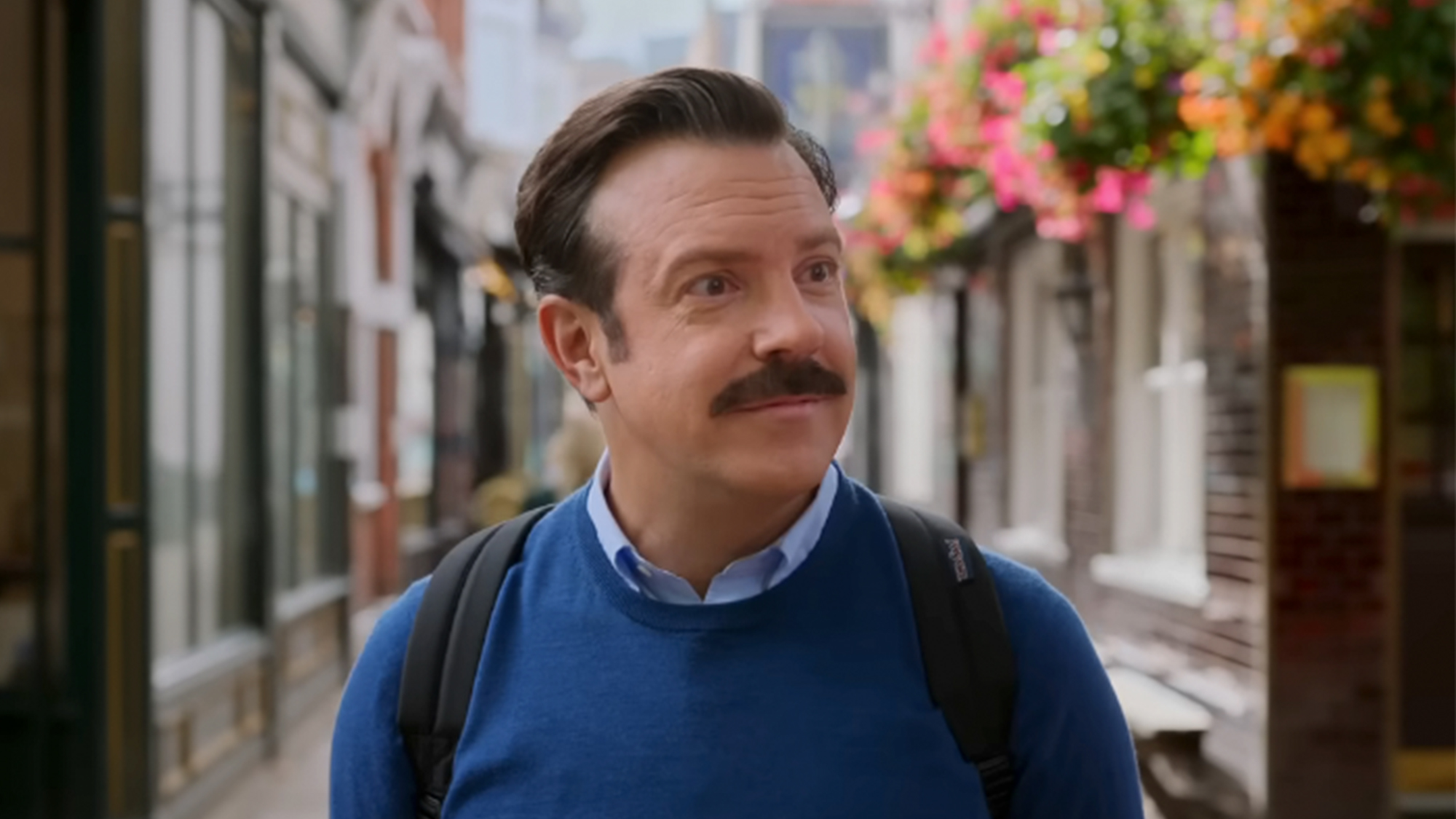 Jason Sudeikis smiling in a blue sweater in Ted Lasso
