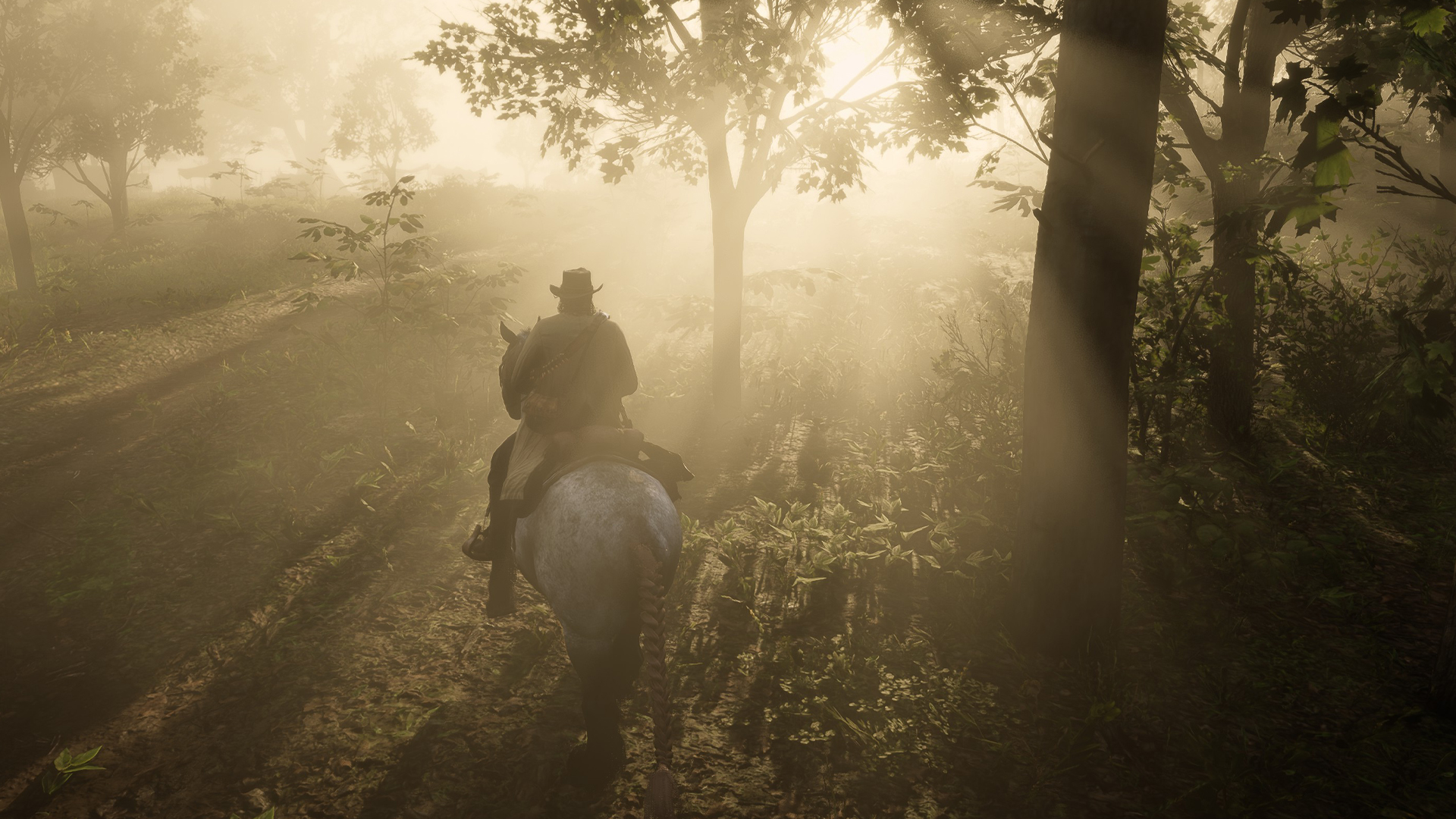 Arthur Morgan rides a horse through the forest at sunrise in Red Dead Redemption 2.