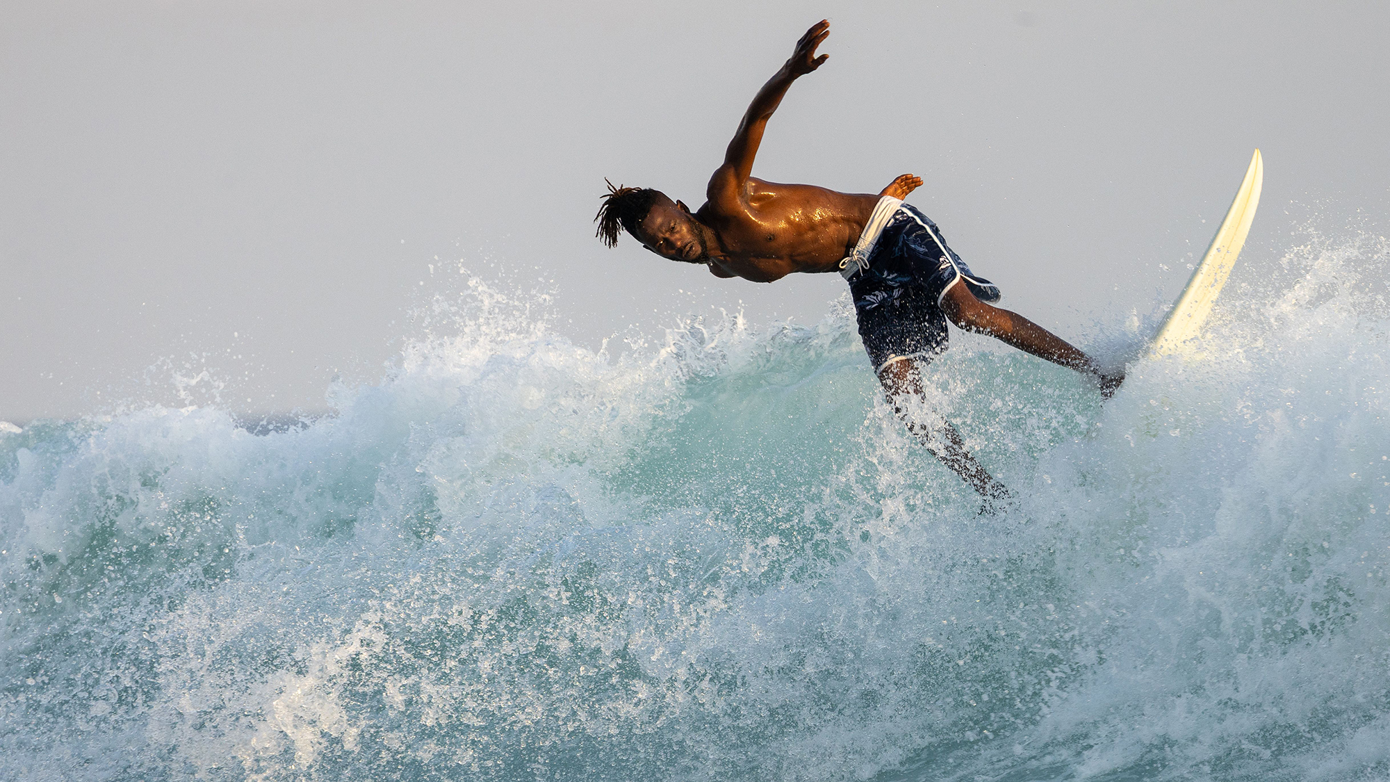A surfer rides the waves off the coast of Dakar, Senegal