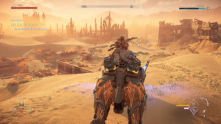 Aloy riding through a desert in Horizon Forbidden West.