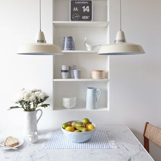 Dining table with a fruit bowl and pendant lighting