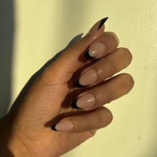 eden stuart with black french tip press ons on a yellow background