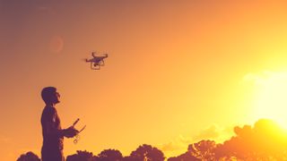 Man with his drone and sunset in background