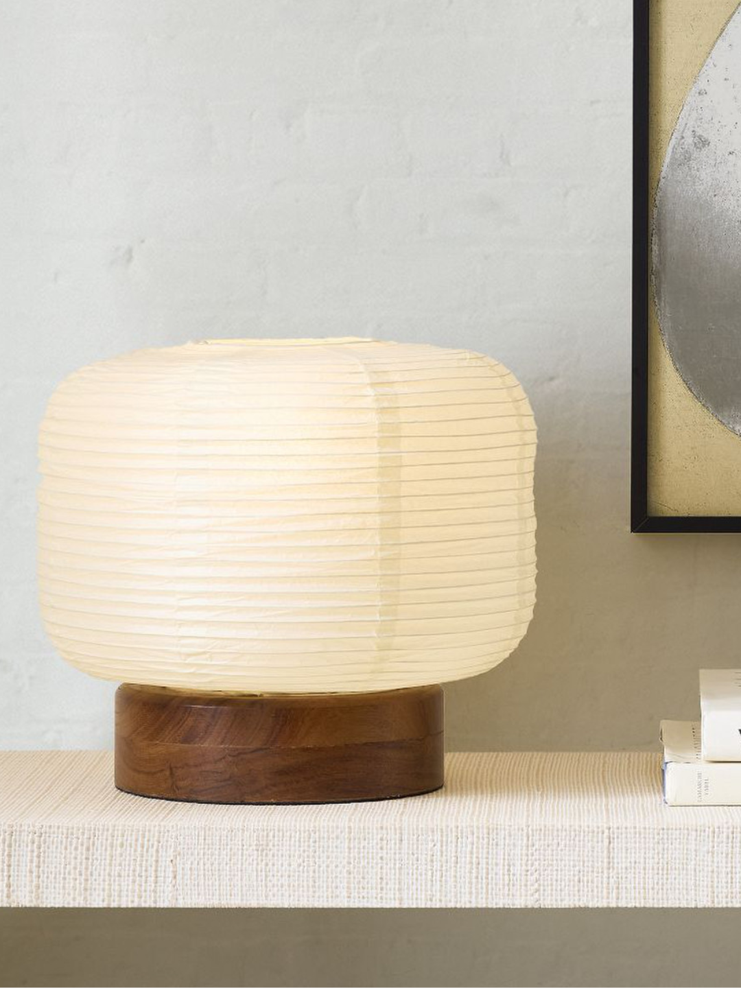 A paper lamp with a wood base from West Elm on a white textured side table