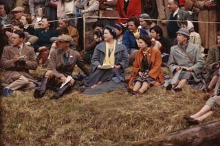 Queen Elizabeth II and the Queen Mother sitting on the ground to watch the Badminton Horse Trials, 1956. On the Queen's other side is Mary, Countess of Harewood (1897 - 1965). Photo by Serge Lemoine/Getty Images