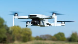 Potensic Atom 2 drone flying with blue sky and trees behind