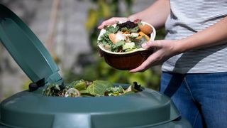 woman taking a bowl of recylcing out to her compost bin