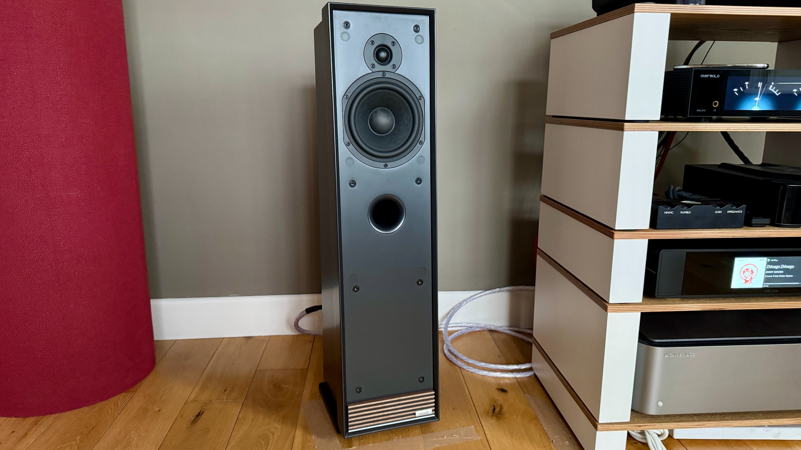 Ruark Audio Talisman-R floorstanding speaker on a wooden floor, next to a hi-fi system