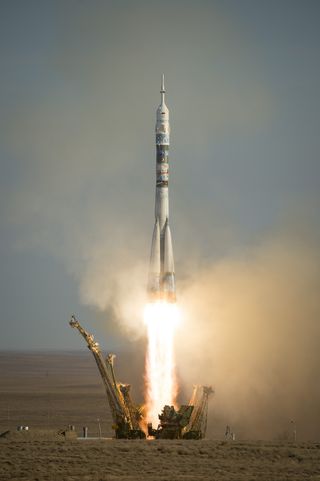 A Soyuz TMA-11M rocket launches with the Olympic torch and Expedition 38 Soyuz Commander Mikhail Tyurin of Roscosmos, Flight Engineer Rick Mastracchio of NASA and Flight Engineer Koichi Wakata of the Japan Aerospace Exploration Agency onboard, Thursday, N
