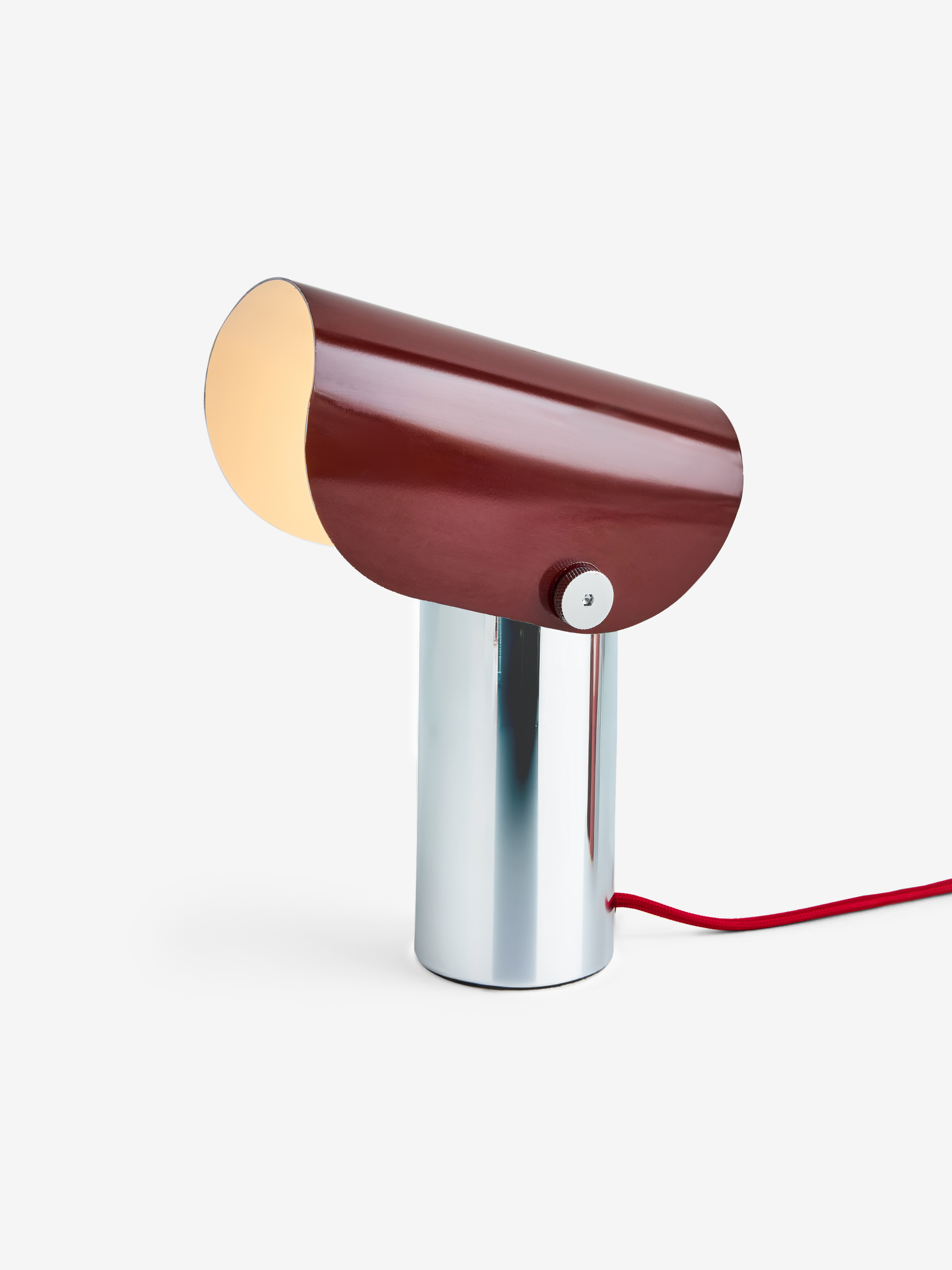 a red table lamp with silvery base
