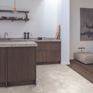 Open plan kitchen with light flooring and dark cabinets