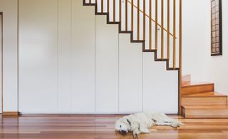 A timber staircase sweeps down the centre of the property, connecting the house’s two levels