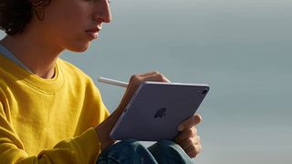 A person using an Apple Pencil with an iPad mini.