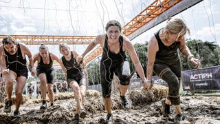 A group of women running through electric eel obstacle