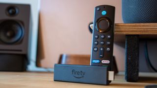 Amazon Fire TV Stick 4K Max with Alexa Voice Remote leaning on desk
