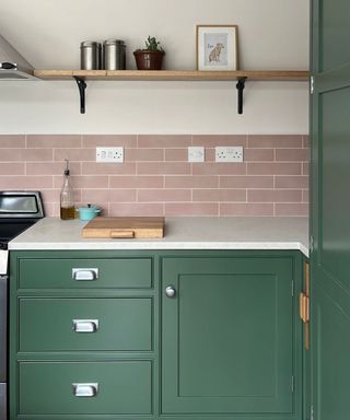 A pink and green kitchen with retro chrome hardware