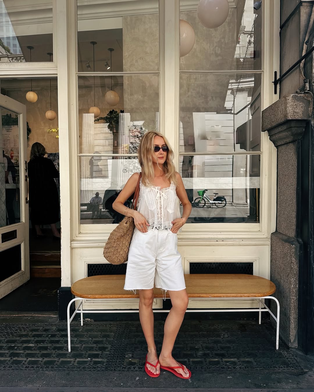 Woman Wearing White Blouse, Denim Shorts, and Red Flip Flops