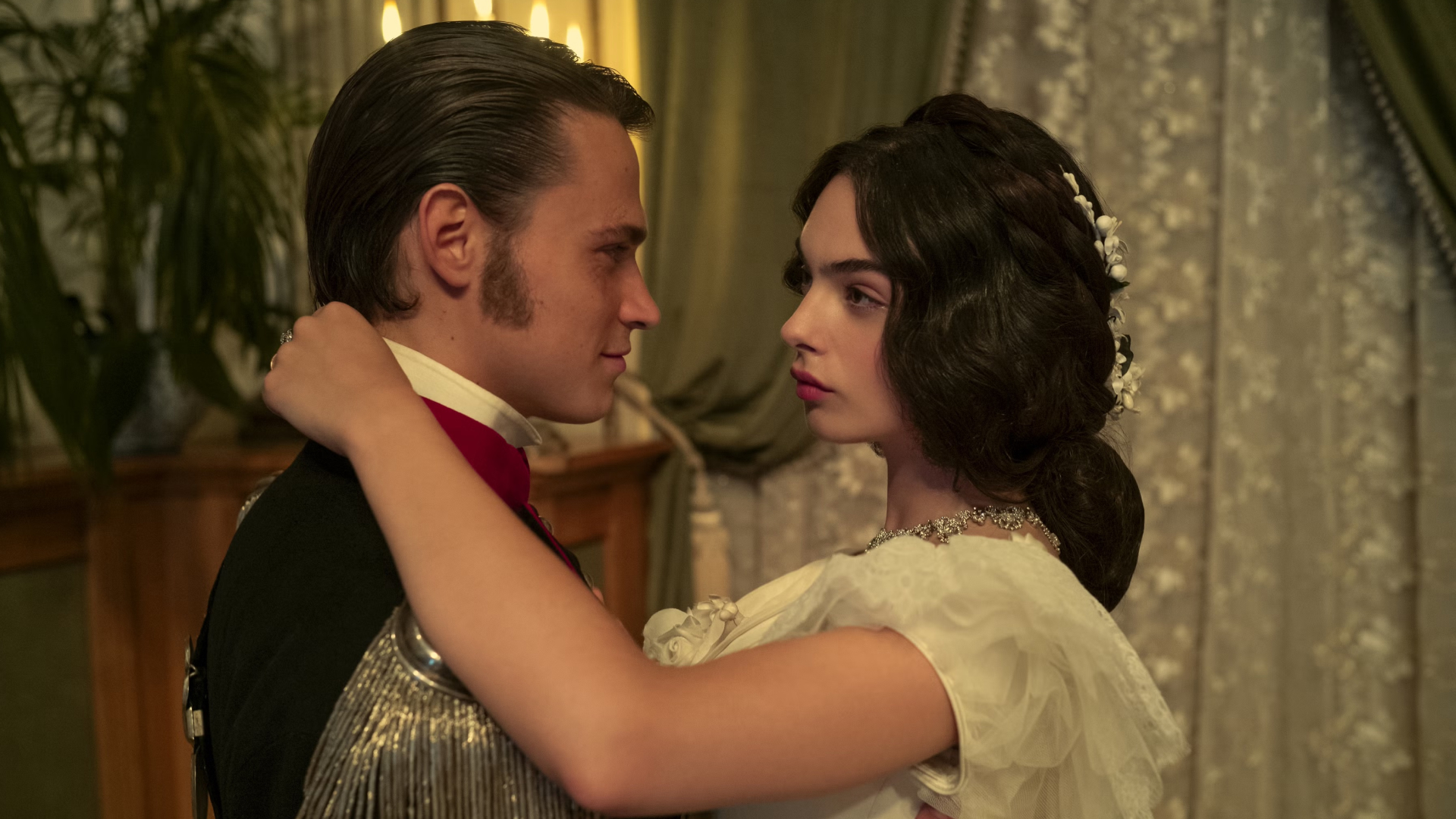 a man in a period war uniform and a woman in a white gown dance together in a still from the leopard