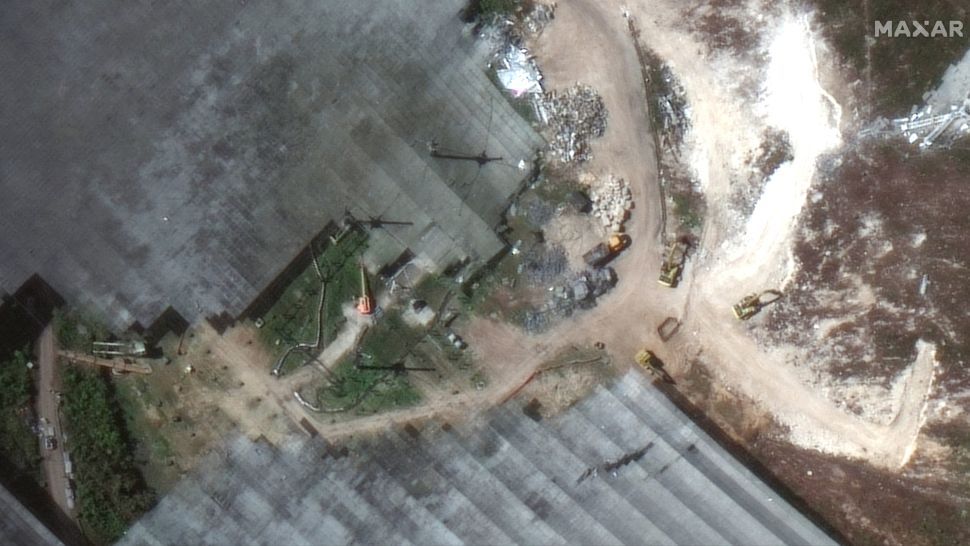 A closeup view of a satellite image captured on Feb. 23, 2021, shows cleanup crews working to dissemble the Arecibo Observatory&#039;s radio telescope.