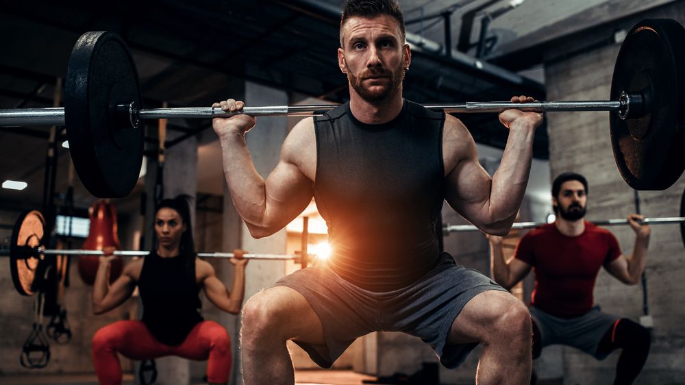 Group of people performing barbell squat