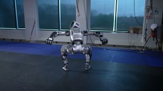 A screenshot of a video showing the new version of the Boston Dynamics Atlas robot, rising upwards in menacing fashion