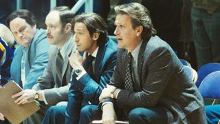 Adrien Brody and Jason Segel as Pat Riley and Paul Westhead sitting during a game in Winning Time season 2 episode 4