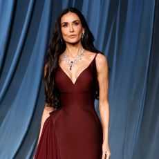 Demi Moore wearing a burgundy spaghetti strap dress.